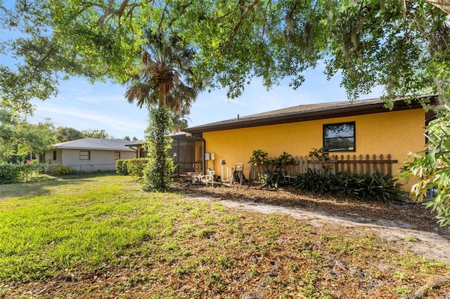 2192 Hyatt Dr, Port Charlotte, FL 33948 - exterior space featuring stucco siding, fence, glass enclosure, and a lawn