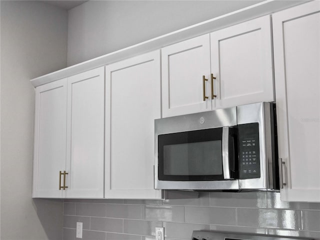 4425 Lagoon Ter, North Port, FL 34286 - kitchen view of stainless steel microwave, white cabinets, and backsplash