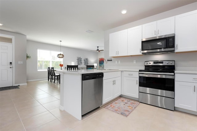7209 W Lenox Cir, Punta Gorda, FL 33950 - kitchen with white cabinets, light countertops, a peninsula, and stainless steel appliances