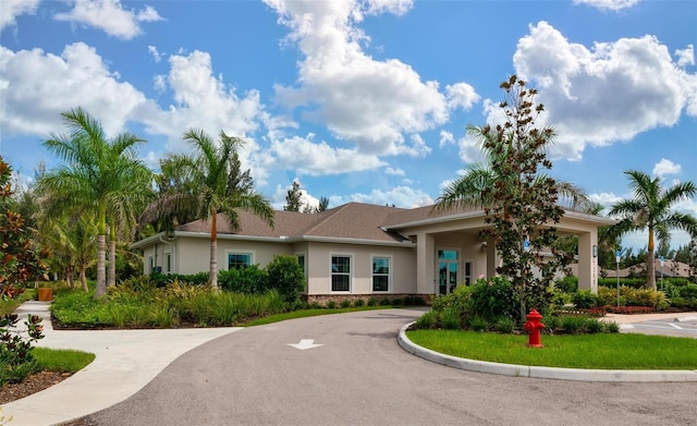 7209 W Lenox Cir, Punta Gorda, FL 33950 - view of front of property featuring stucco siding, stone siding, and curved driveway