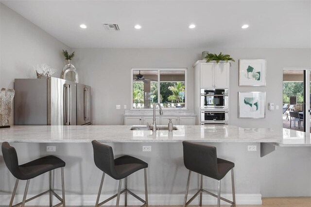 7209 W Lenox Cir, Punta Gorda, FL 33950 - kitchen featuring light stone counters, recessed lighting, white cabinets, stainless steel appliances, and a sink