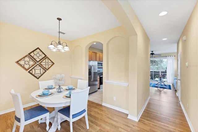 1085 Jonah Dr, North Port, FL 34289 - dining area with arched walkways, light wood-style flooring, a chandelier, and recessed lighting