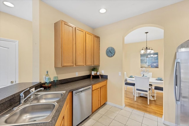 1085 Jonah Dr, North Port, FL 34289 - kitchen featuring appliances with stainless steel finishes, light tile patterned floors, dark countertops, decorative light fixtures, and recessed lighting