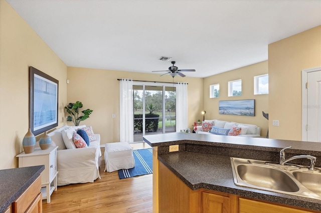 1085 Jonah Dr, North Port, FL 34289 - kitchen with open floor plan, light wood-style flooring, dark countertops, and a ceiling fan