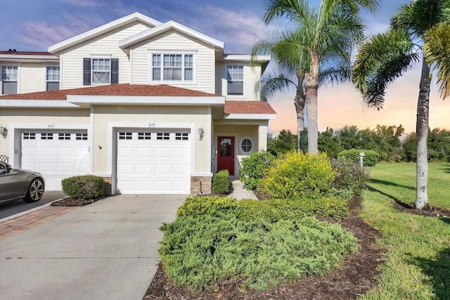 1085 Jonah Dr, North Port, FL 34289 - view of front of home with driveway, an attached garage, a shingled roof, stucco siding, and a front yard