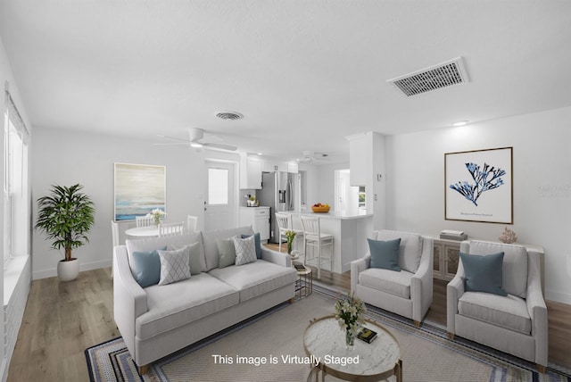 living area featuring visible vents, plenty of natural light, and ceiling fan