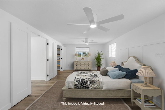 bedroom with baseboards, a ceiling fan, and wood finished floors