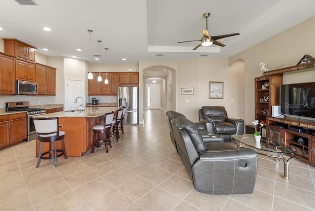 living room featuring light tile patterned floors, ceiling fan, recessed lighting, and arched walkways