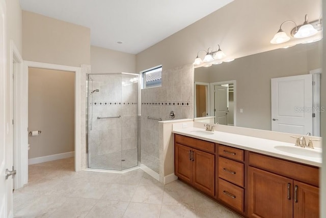 full bathroom featuring a shower stall, tile patterned floors, double vanity, and a sink