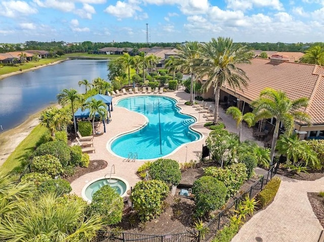 community pool featuring a water view, a patio, and a community hot tub