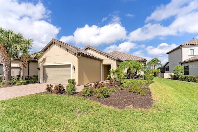 mediterranean / spanish home featuring stucco siding, decorative driveway, a front yard, a tile roof, and a garage