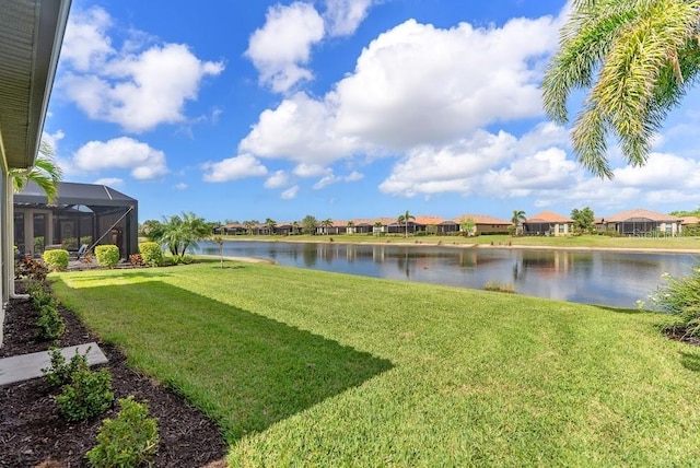 view of yard featuring a water view, glass enclosure, and a residential view