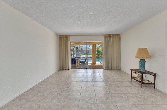 3824 Aves Island Ct, Punta Gorda, FL 33950 - empty room featuring light tile patterned floors, a sunroom, and a textured ceiling
