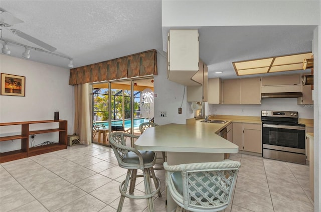 3824 Aves Island Ct, Punta Gorda, FL 33950 - kitchen with stainless steel electric range, a peninsula, light countertops, light tile patterned flooring, and a sink