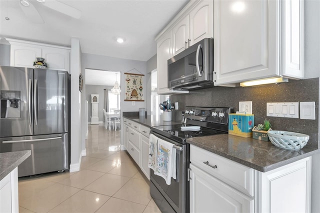 kitchen with backsplash, appliances with stainless steel finishes, light tile patterned floors, and white cabinetry