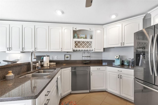kitchen with open shelves, white cabinets, light tile patterned flooring, a sink, and stainless steel fridge