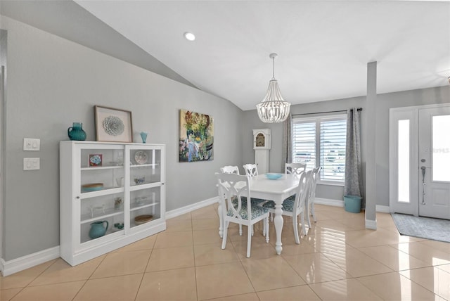 tiled dining room featuring a chandelier, baseboards, and vaulted ceiling