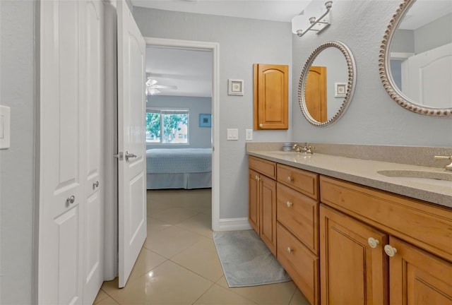 bathroom featuring tile patterned floors, double vanity, ensuite bath, and a sink