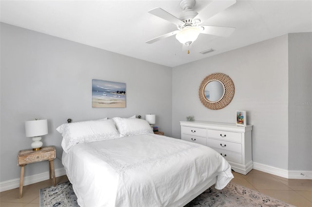 bedroom featuring light tile patterned floors, visible vents, baseboards, and ceiling fan