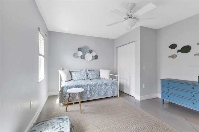 tiled bedroom featuring a closet, ceiling fan, and baseboards