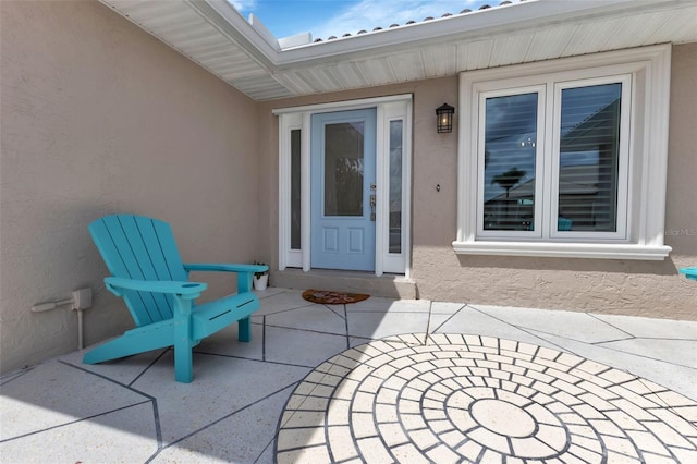 doorway to property featuring a patio and stucco siding