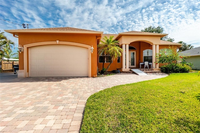 view of front of home with driveway, covered porch, stucco siding, a front lawn, and a garage