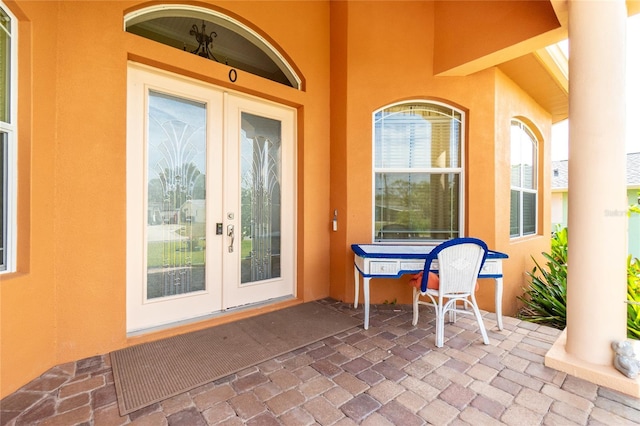 property entrance featuring stucco siding, a patio area, and french doors