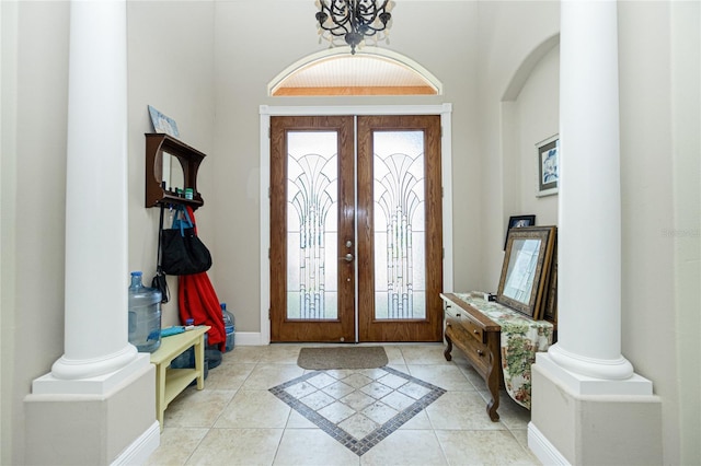 entryway with light tile patterned floors, arched walkways, a notable chandelier, and french doors