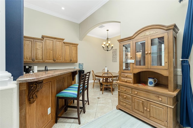 interior space featuring pendant lighting, crown molding, arched walkways, an inviting chandelier, and recessed lighting