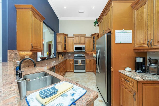 kitchen with tasteful backsplash, brown cabinets, a sink, visible vents, and stainless steel appliances