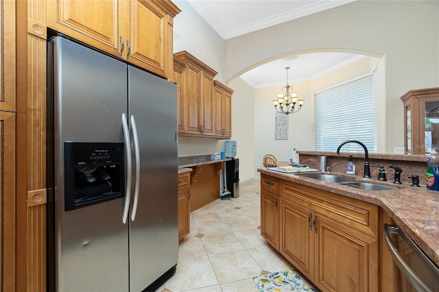 kitchen with brown cabinets, a sink, crown molding, arched walkways, and appliances with stainless steel finishes