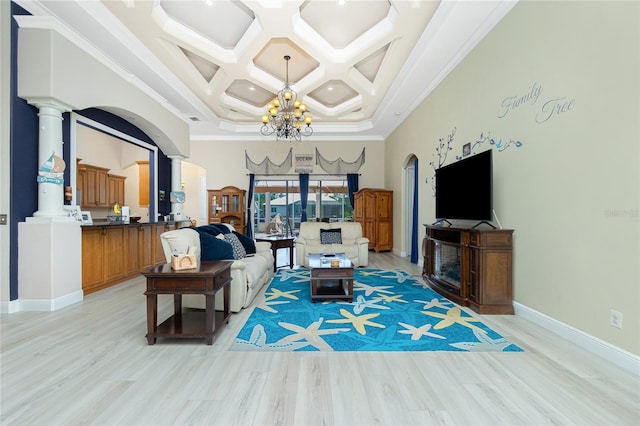 living area with coffered ceiling, an inviting chandelier, a towering ceiling, and light wood-style floors