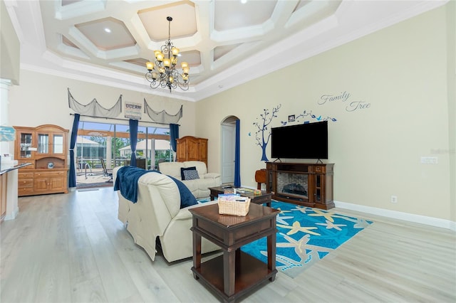 living room featuring arched walkways, coffered ceiling, light wood-style flooring, a notable chandelier, and a towering ceiling