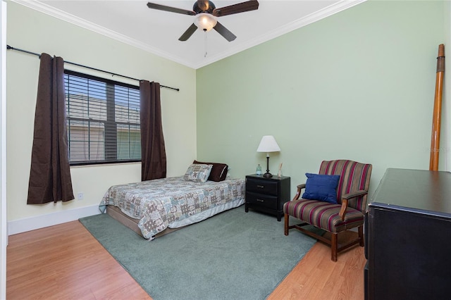 bedroom with ornamental molding, ceiling fan, wood finished floors, and baseboards