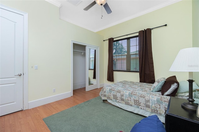 bedroom featuring baseboards, visible vents, wood finished floors, and crown molding