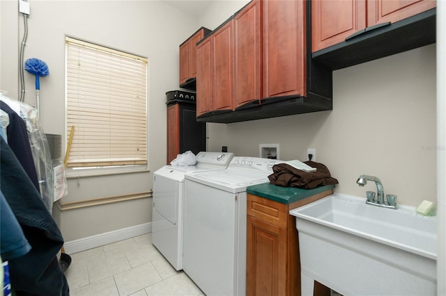laundry room with light tile patterned floors, washer and dryer, cabinet space, and a sink