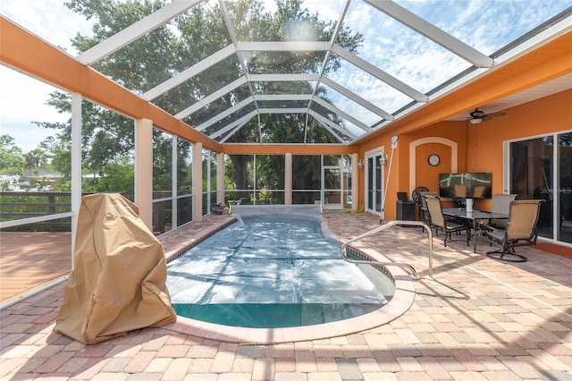 outdoor pool featuring a patio, glass enclosure, a ceiling fan, and outdoor dining area
