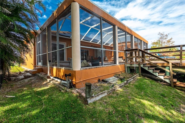 view of side of home with a yard and a lanai