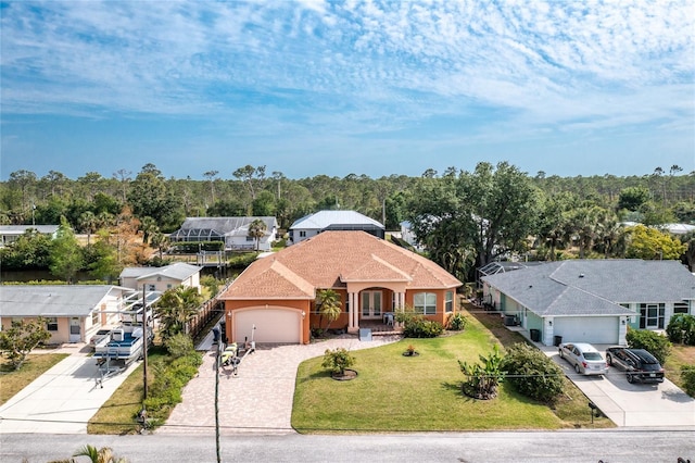view of front of home featuring a front yard, driveway, a garage, and stucco siding