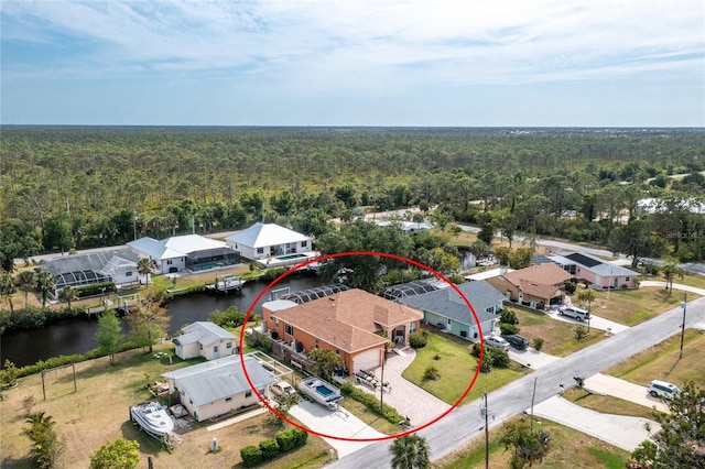 bird's eye view with a wooded view, a residential view, and a water view