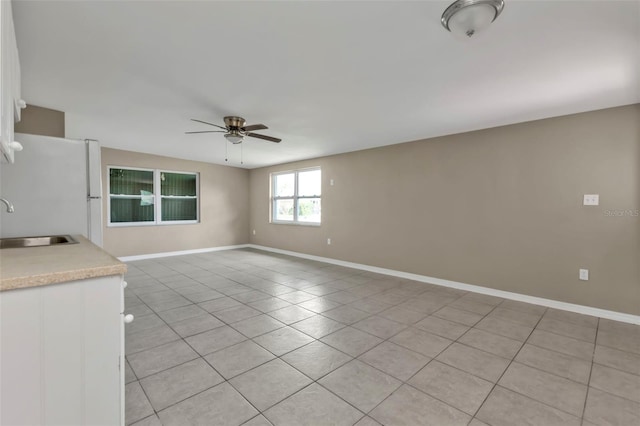 21242 Coulton Ave, Port Charlotte, FL 33952 - unfurnished living room featuring baseboards, light tile patterned floors, a sink, and a ceiling fan