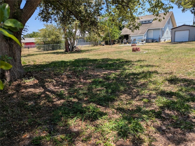 view of yard featuring fence and a garage