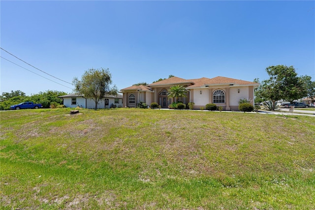 8315 Raoul Ave, North Port, FL 34291 - mediterranean / spanish home featuring a front lawn and stucco siding