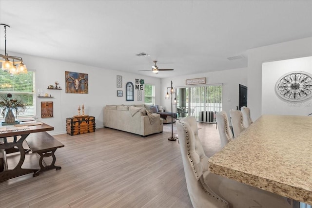 3476 Brewster Rd, North Port, FL 34288 - living room featuring visible vents, ceiling fan with notable chandelier, and light wood-style flooring