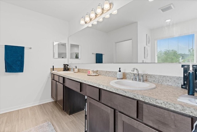 3476 Brewster Rd, North Port, FL 34288 - full bathroom with double vanity, visible vents, a sink, and wood finished floors