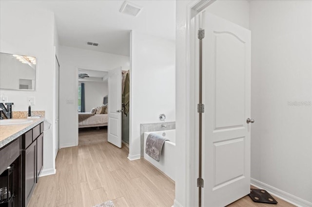 3476 Brewster Rd, North Port, FL 34288 - bathroom featuring a bath, baseboards, connected bathroom, and vanity