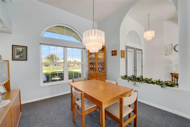 229 Sportsman Rd, Rotonda West, FL 33947 - dining area with a chandelier, dark colored carpet, plenty of natural light, and arched walkways