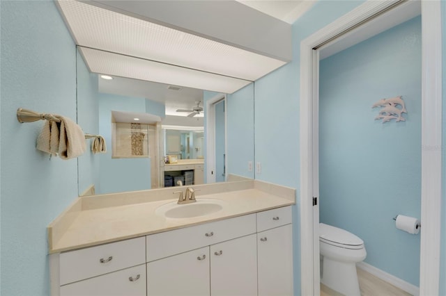 229 Sportsman Rd, Rotonda West, FL 33947 - bathroom featuring vanity, baseboards, toilet, and ceiling fan