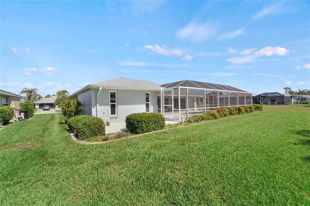 229 Sportsman Rd, Rotonda West, FL 33947 - rear view of house featuring stucco siding, glass enclosure, and a lawn