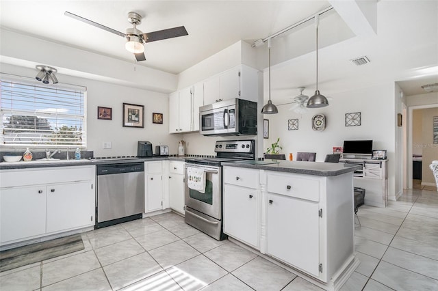 242 Seminole Blvd NW, Port Charlotte, FL 33952 - kitchen featuring ceiling fan, a peninsula, white cabinetry, appliances with stainless steel finishes, and dark countertops